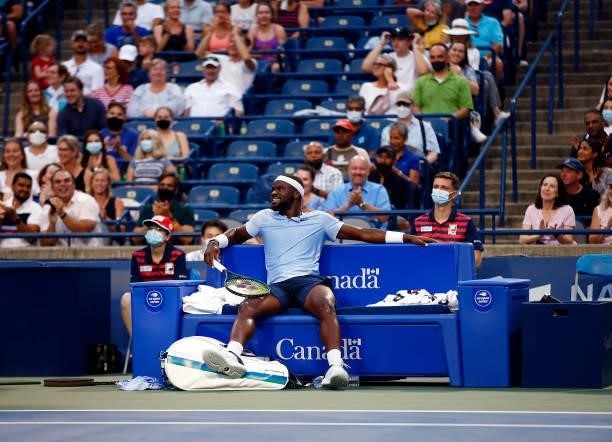 Frances Tiafoe of the United States chases a ball and ends up falling into his courtside seat during his second round match against Denis Shapovalov...