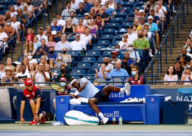 Frances Tiafoe of the United States chases a ball and ends up falling into his courtside seat during his second round match against Denis Shapovalov...