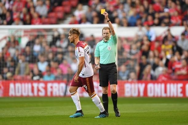 Referee, Peter Wright shows a yellow card to Finn Cousin-Dawson of Bradford City during the Carabao Cup match between Nottingham Forest and Bradford...