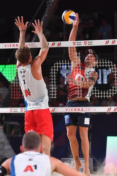 Alexander Horst of Austria spikes ans Marco Krattiger of Switzerland blocks during the pool match between Marco Krattiger and Yves Haussener of...