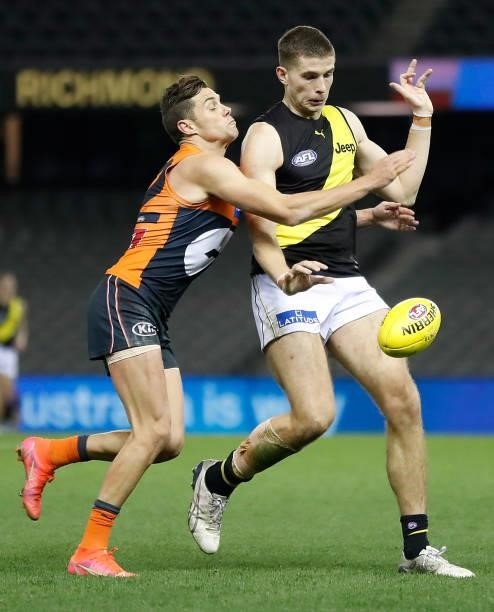 Callum Coleman-Jones of the Tigers is tackled by Josh Kelly of the Giants during the 2021 AFL Round 22 match between the GWS Giants and the Richmond...