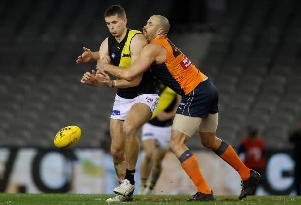 Callum Coleman-Jones of the Tigers is tackled by Shane Mumford of the Giants during the 2021 AFL Round 22 match between the GWS Giants and the...