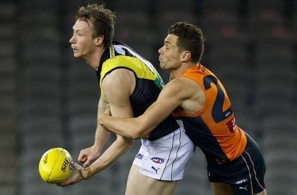 Dylan Grimes of the Tigers is tackled by Josh Kelly of the Giants during the 2021 AFL Round 22 match between the GWS Giants and the Richmond Tigers...