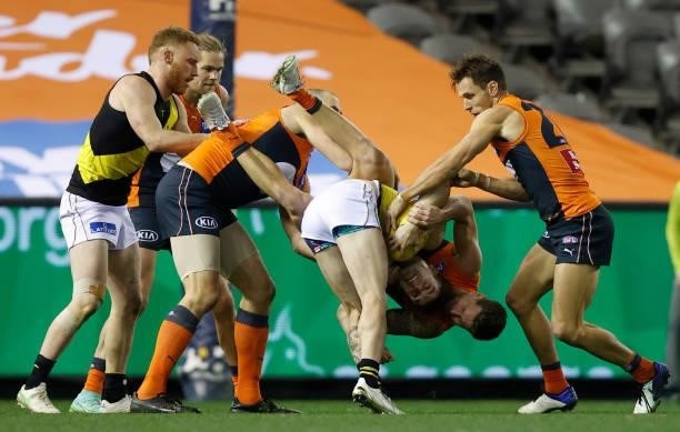 Jayden Short of the Tigers is tackled by Daniel Lloyd of the Giants during the 2021 AFL Round 22 match between the GWS Giants and the Richmond Tigers...