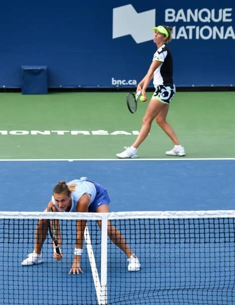 Elise Mertens of Belgium prepares to serve while teammate Aryna Sabalenka of Belarus crouches near the net during their Womens Doubles Quarterfinals...