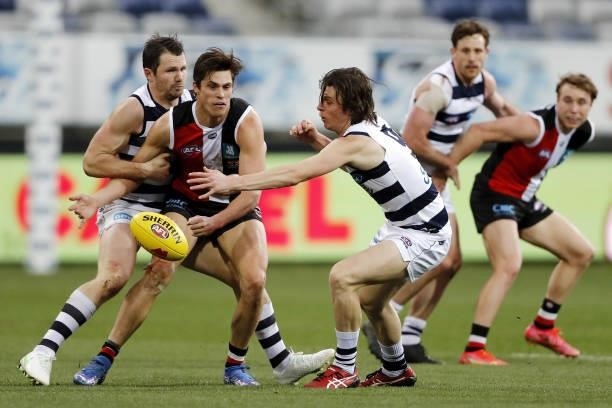Jack Steele of the Saints is tackled by Patrick Dangerfield of the Cats and Max Holmes of the Cats during the 2021 AFL Round 22 match between the...