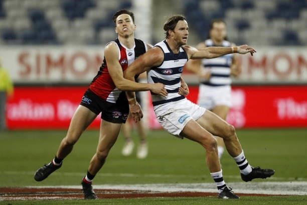 Lachie Henderson of the Cats is tackled by Cooper Sharman of the Saints during the 2021 AFL Round 22 match between the Geelong Cats and the St Kilda...