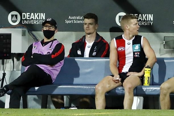 Darragh Joyce of the Saints is seen sitting on the bench in his tracksuit after being substituted out of the game during the 2021 AFL Round 22 match...