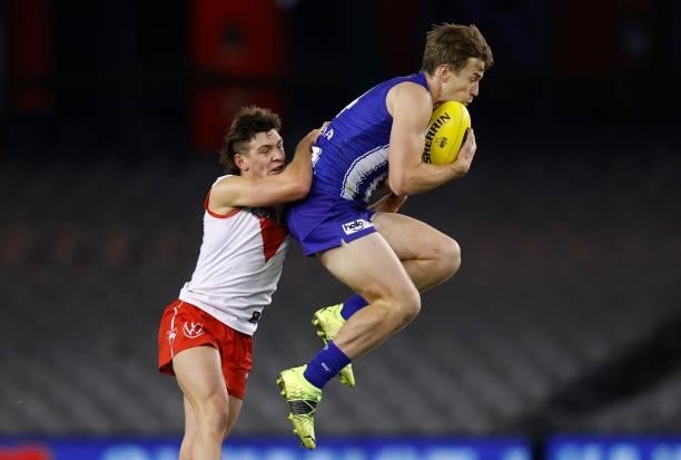 Trent Dumont of the Kangaroos and Errol Gulden of the Swans compete for the ball during the 2021 AFL Round 22 match between the North Melbourne...