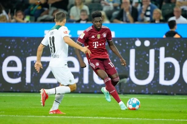 Stefan Lainer of Borussia Moenchengladbach and Alphonso Davies of Bayern Muenchen battle for the ball during the Bundesliga match between Borussia...
