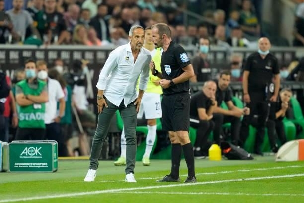 Head coach Adi Huetter of Borussia Moenchengladbach talks to referee Marco Fritz during the Bundesliga match between Borussia Moenchengladbach and FC...