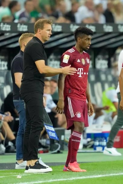 Head coach Julian Nagelsmann of Bayern Muenchen talks to Kingsley Coman of Bayern Muenchen during the Bundesliga match between Borussia...