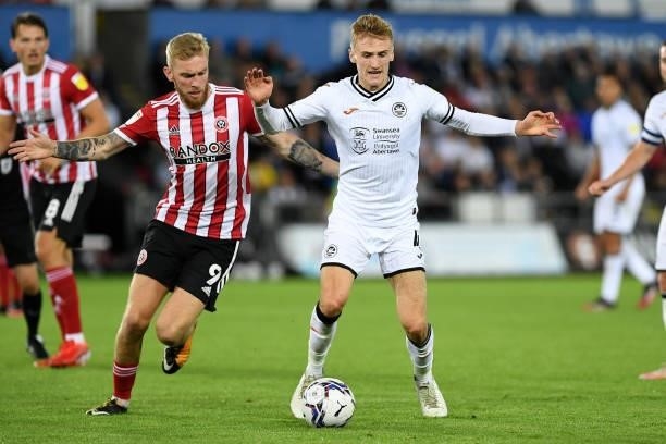 Oli McBurnie of Sheffield United battles with Flynn Downes of Swansea City during the Sky Bet Championship match between Swansea City and Sheffield...
