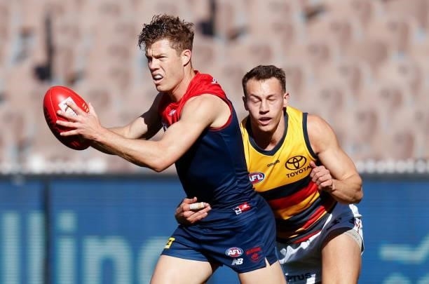 Jake Melksham of the Demons is tackled by Tom Doedee of the Crows during the 2021 AFL Round 22 match between the Melbourne Demons and the Adelaide...