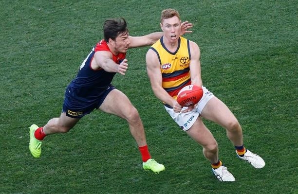 Tom Lynch of the Crows is tackled by Michael Hibberd of the Demons during the 2021 AFL Round 22 match between the Melbourne Demons and the Adelaide...