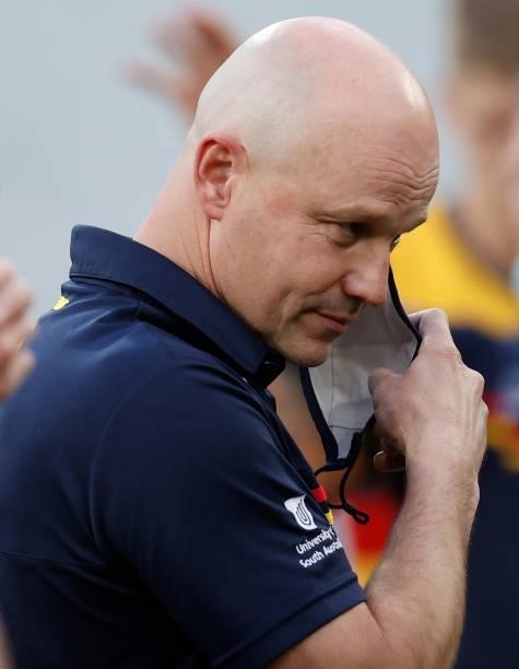 Senior coach Matthew Nicks of the Crows removes his mask during the 2021 AFL Round 22 match between the Melbourne Demons and the Adelaide Crows at...