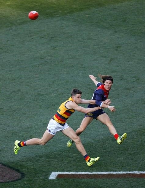 Ed Langdon of the Demons and Paul Seedsman of the Crows in action during the 2021 AFL Round 22 match between the Melbourne Demons and the Adelaide...