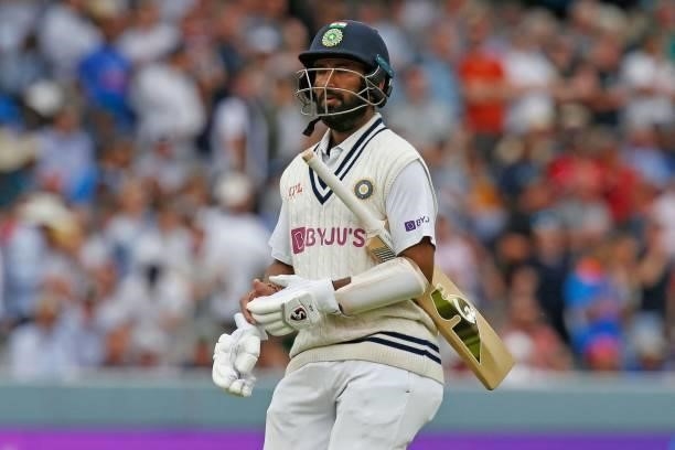 India's Cheteshwar Pujara walks back to the pavilion after losing his wicket for 45 runs on the fourth day of the second cricket Test match between...