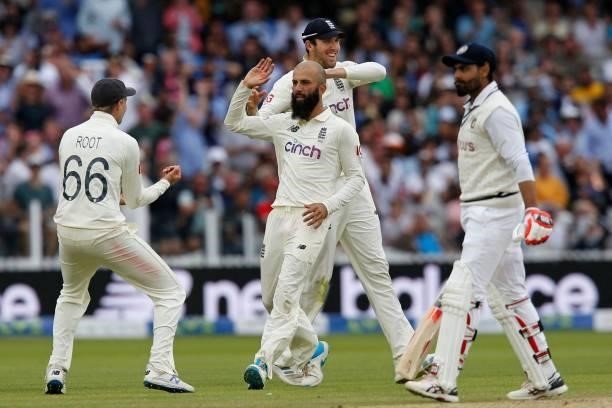 England's Moeen Ali celebrates with teammates after taking the wicket of India's Ravindra Jadeja for 3 runs on the fourth day of the second cricket...
