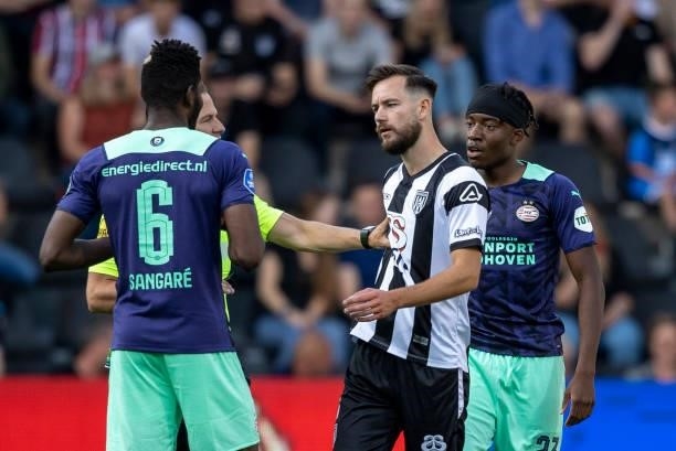 Orestis Kiomourtzoglou of Heracles Almelo and Ibrahim Sangare of PSV Eindhoven speaks with during the Dutch Eredivisie match between Heracles Almelo...