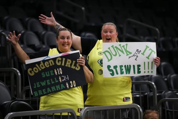 Seattle Storm fans pose with signs during the game against the Connecticut Sun during the WNBA Commissioner's Cup Game on August 12, 2021 at...