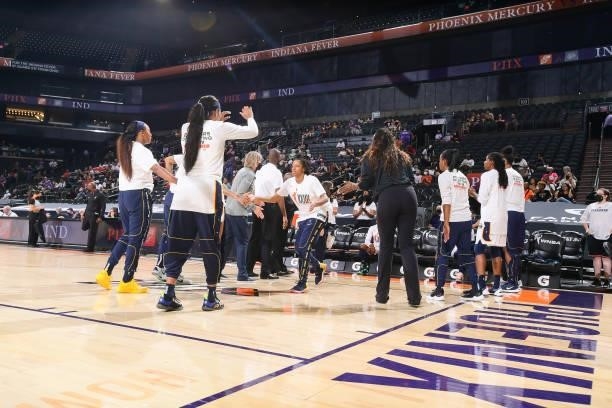 Kelsey Mitchell of the Indiana Fever high fives her teammates before the game against the Phoenix Mercury on August 17, 2021 at Footprint Center in...