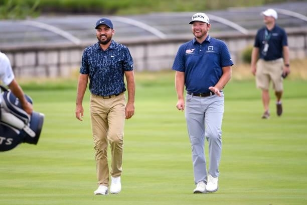 Jason Day of Australia and Matthew NeSmith laugh and talk in the 18th fairway during the first round of THE NORTHERN TRUST at Liberty National Golf...
