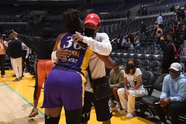Trae Young of the Atlanta Hawks hugs Nneka Ogwumike of the Los Angeles Sparks after the game against the Atlanta Dream on August 19, 2021 at the...