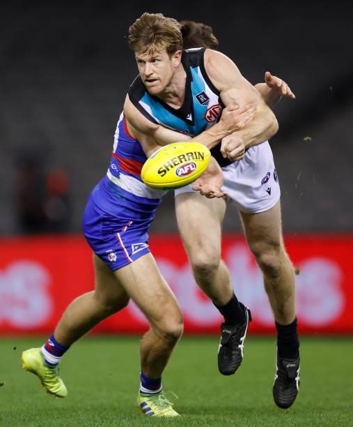 Tom Jonas of the Power is tackled by Laitham Vandermeer of the Bulldogs during the 2021 AFL Round 23 match between the Western Bulldogs and the Port...