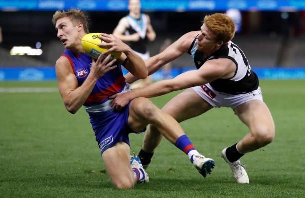 Roarke Smith of the Bulldogs is tackled by Willem Drew of the Power during the 2021 AFL Round 23 match between the Western Bulldogs and the Port...