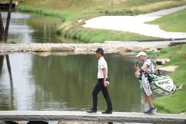 Kevin Na is seen with his caddie walking off the 16th hole during the second round of THE NORTHERN TRUST at Liberty National Golf Club on August 20,...
