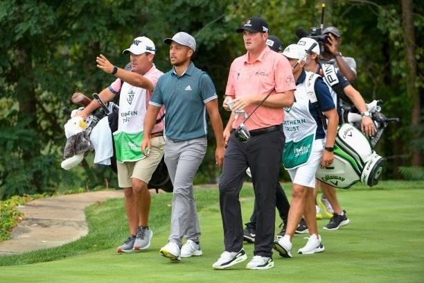 Xander Schauffele and Jason Kokrak leave the 18th tee during the second round of THE NORTHERN TRUST at Liberty National Golf Club on August 20, 2021...