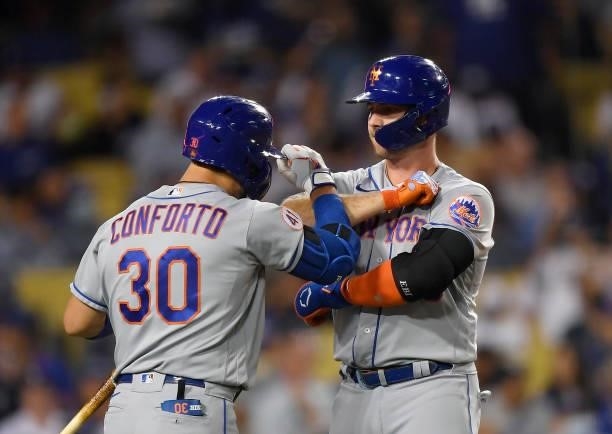Pete Alonso of the New York Mets celebrates his solo home run with Michael Conforto against starting pitcher Walker Buehler of the Los Angeles...