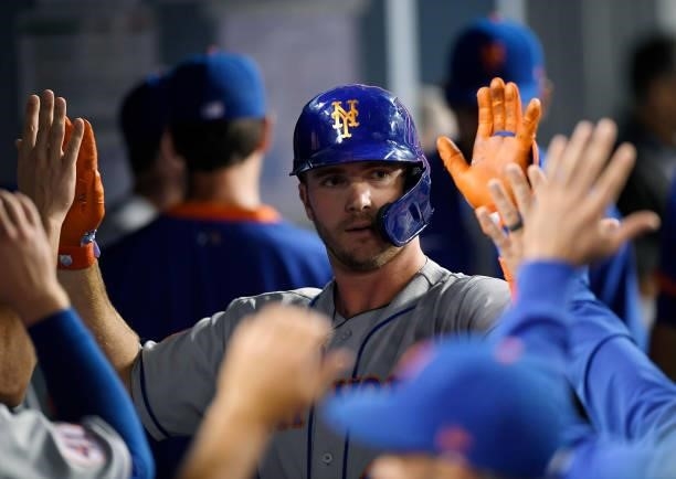Pete Alonso of the New York Mets is congratulated in the dugout after hitting a solo home run against starting pitcher Walker Buehler of the Los...