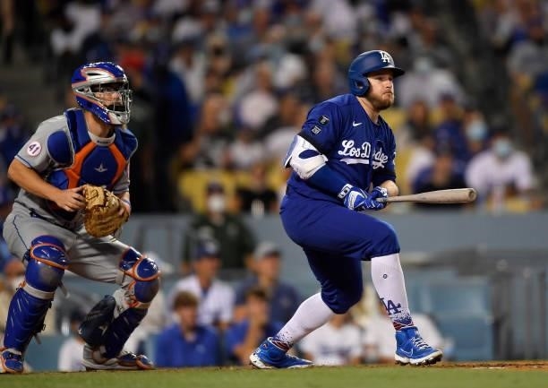 Max Muncy of the Los Angeles Dodgers and catcher Patrick Mazeika of the New York Mets watch as Muncy hits a one run base hit to score Trea Turner...