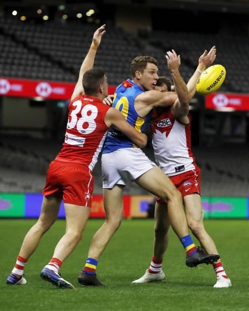 Josh Corbett of the Suns competes for the ball against Colin O'Riordan and Harry Cunningham of the Swans during the 2021 AFL Round 23 match between...