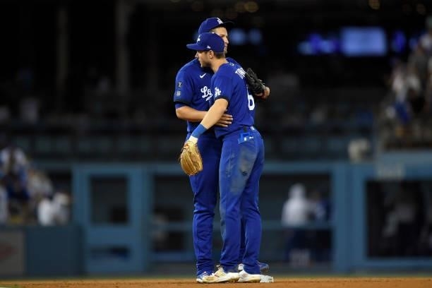 Trea Turner and Corey Seager of the Los Angeles Dodgers his as they celebrate after defeating the New York Mets, 3-2, at Dodger Stadium on August 20,...