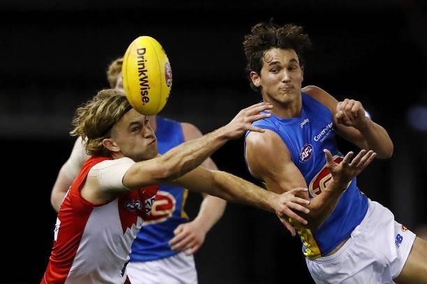 Wil Powell of the Suns handpasses the ball against James Rowbottom of the Swans during the 2021 AFL Round 23 match between the Sydney Swans and the...