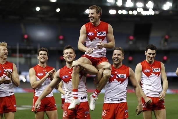 Harry Cunningham of the Swans is chaired off by teammates Luke Parker and Jake Lloyd after his 150th match during the 2021 AFL Round 23 match between...