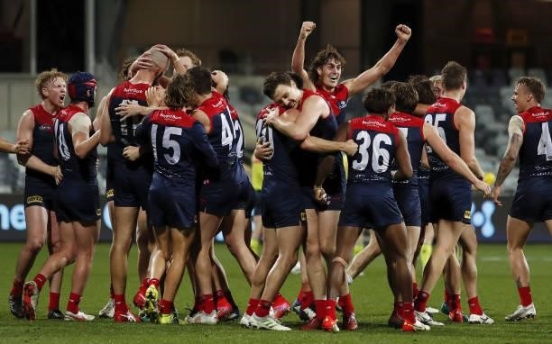 Melbourne players celebrate after a win during the 2021 AFL Round 23 match between the Geelong Cats and the Melbourne Demons at GMHBA Stadium on...
