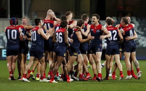 Melbourne players celebrate after a win during the 2021 AFL Round 23 match between the Geelong Cats and the Melbourne Demons at GMHBA Stadium on...