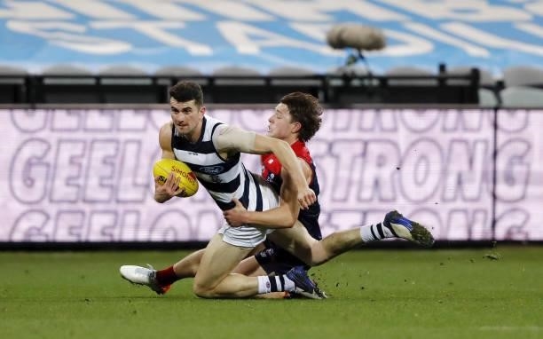 Mark OConnor of the Cats is tackled by Tom Sparrow of the Demons during the 2021 AFL Round 23 match between the Geelong Cats and the Melbourne Demons...