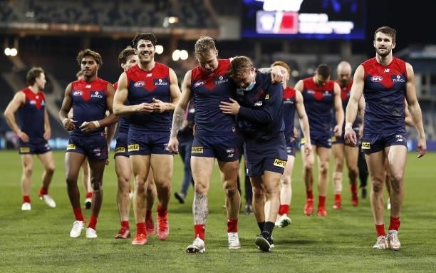 Melbourne players leave the field after a win during the 2021 AFL Round 23 match between the Geelong Cats and the Melbourne Demons at GMHBA Stadium...