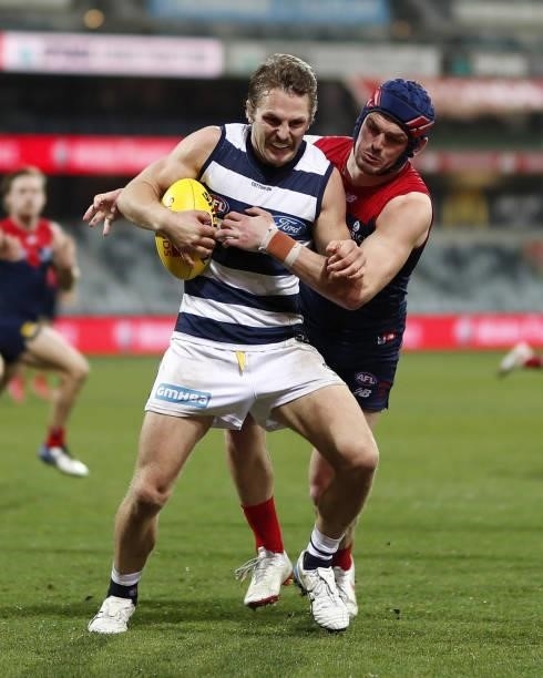 Tom Atkins of the Cats is tackled by Angus Brayshaw of the Demons during the 2021 AFL Round 23 match between the Geelong Cats and the Melbourne...