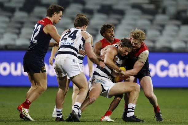 Lachie Henderson of the Cats is tackled by Kysaiah Pickett of the Demons and Clayton Oliver of the Demons during the 2021 AFL Round 23 match between...