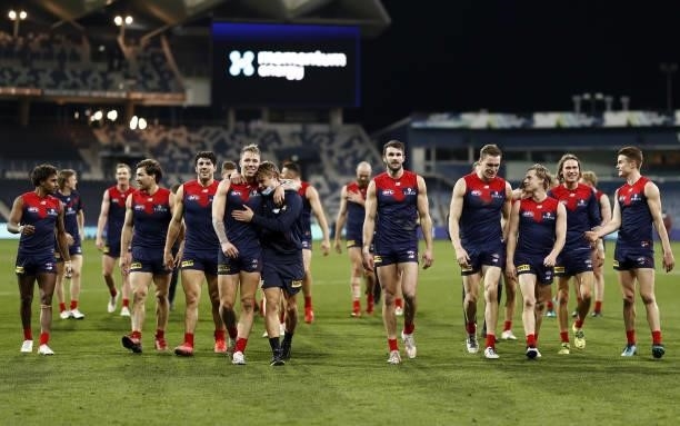 Melbourne players leave the field after a win during the 2021 AFL Round 23 match between the Geelong Cats and the Melbourne Demons at GMHBA Stadium...