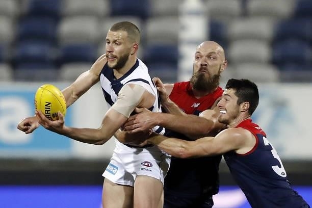 Sam Menegola of the Cats is tackled by Max Gawn of the Demons and Alex Neal-Bullen of the Demons during the 2021 AFL Round 23 match between the...