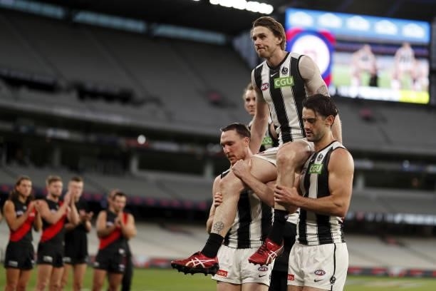 Jordan Roughead of the Magpies is chaired off the ground by Jack Madgen of the Magpies and Brodie Grundy of the Magpies during the 2021 AFL Round 23...