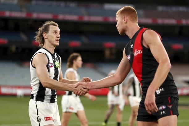 Chris Mayne of the Magpies shakes hands with Peter Wright of the Bombers during the 2021 AFL Round 23 match between the Essendon Bombers and the...