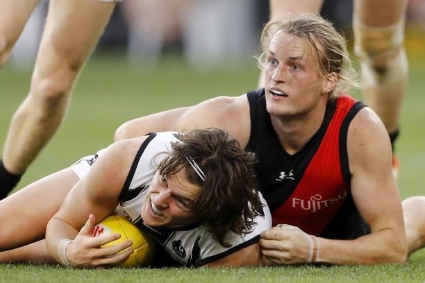 Jack Ginnivan of the Magpies is tackled by Mason Redman of the Bombers during the 2021 AFL Round 23 match between the Essendon Bombers and the...